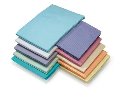 Stack of colorful disposable medical underpads on white background, home care supplies