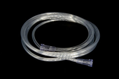 Clear medical oxygen tubing with connectors coiled on a black background