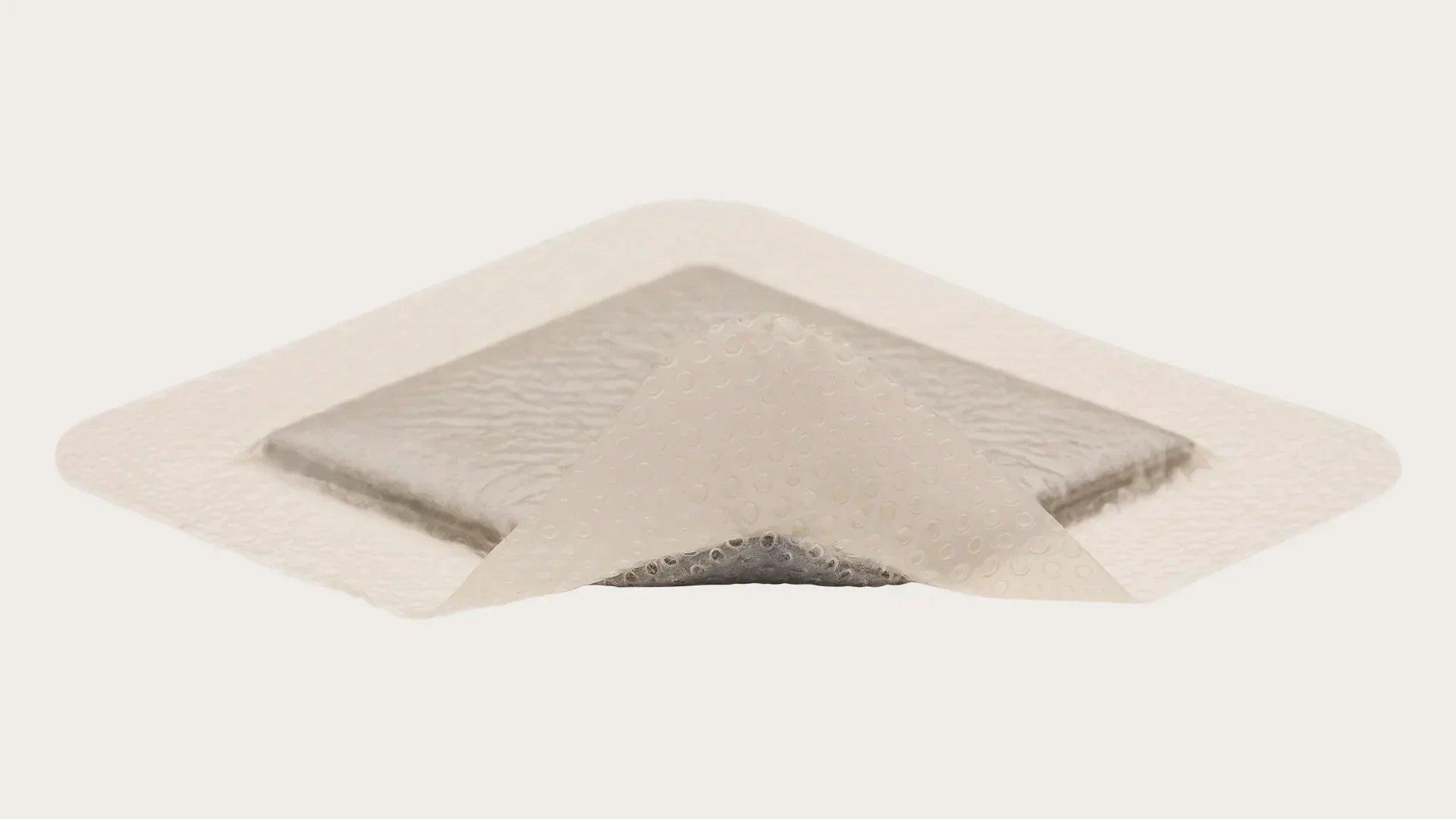 Sterile medical wound dressing with transparent adhesive border on white background