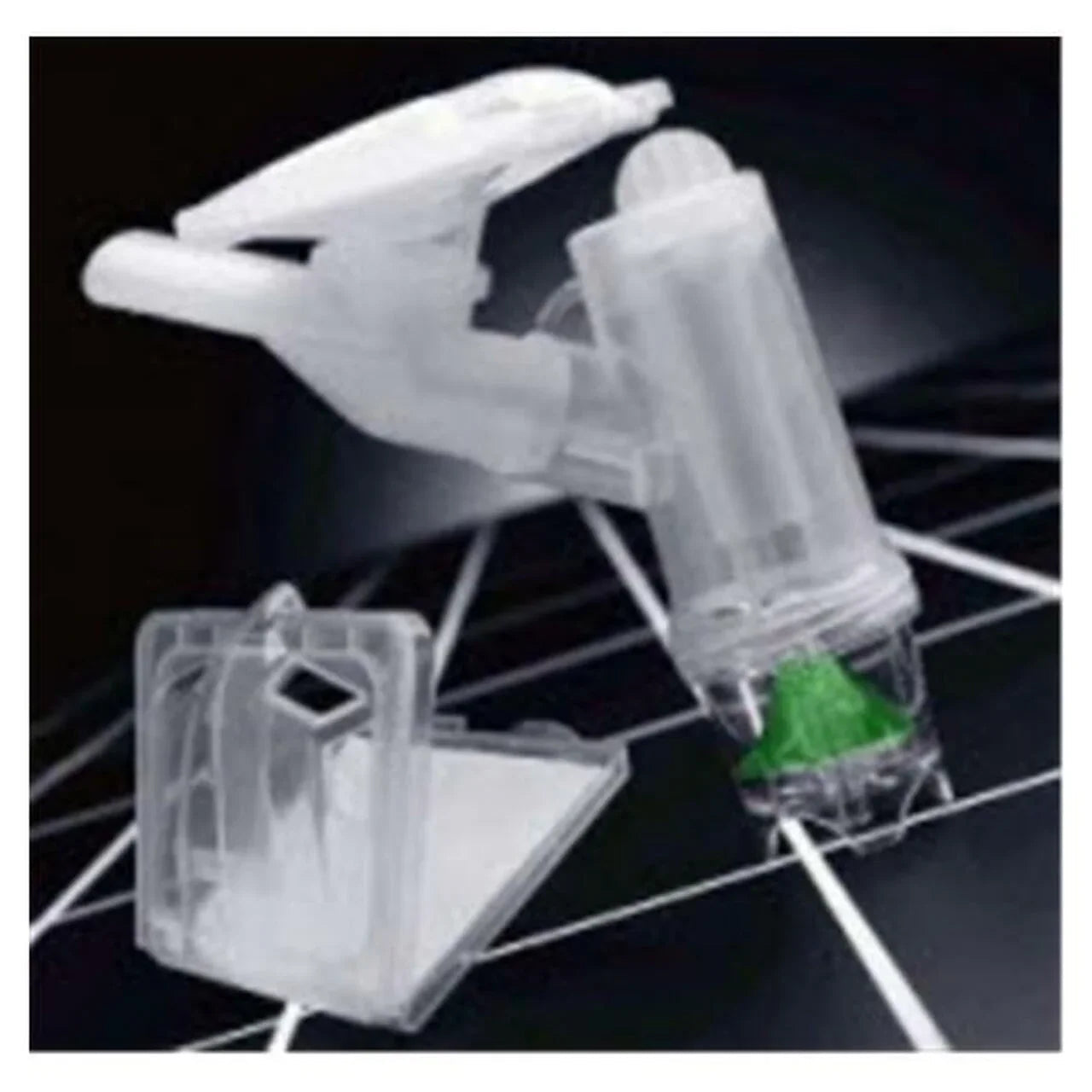 Clear plastic medical nebulizer kit with green valve on black background