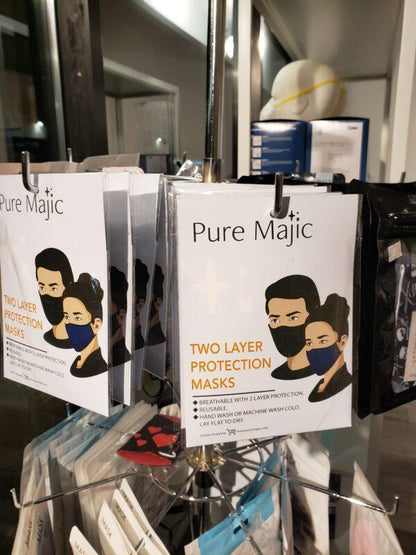 Pure Majic two layer protection face masks displayed in retail packaging on a store rack.
